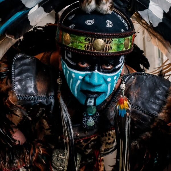 Vibrant tribal costume featuring face paint, feathers, and intricate details.