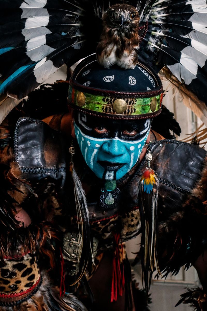 Vibrant tribal costume featuring face paint, feathers, and intricate details.