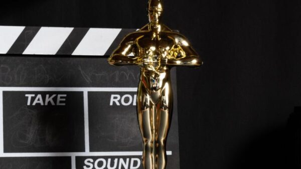 A golden trophy next to a film clapperboard symbolizes cinema success and achievement.