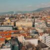 Aerial view of Sarajevo's sprawling cityscape with historic architecture and hills.
