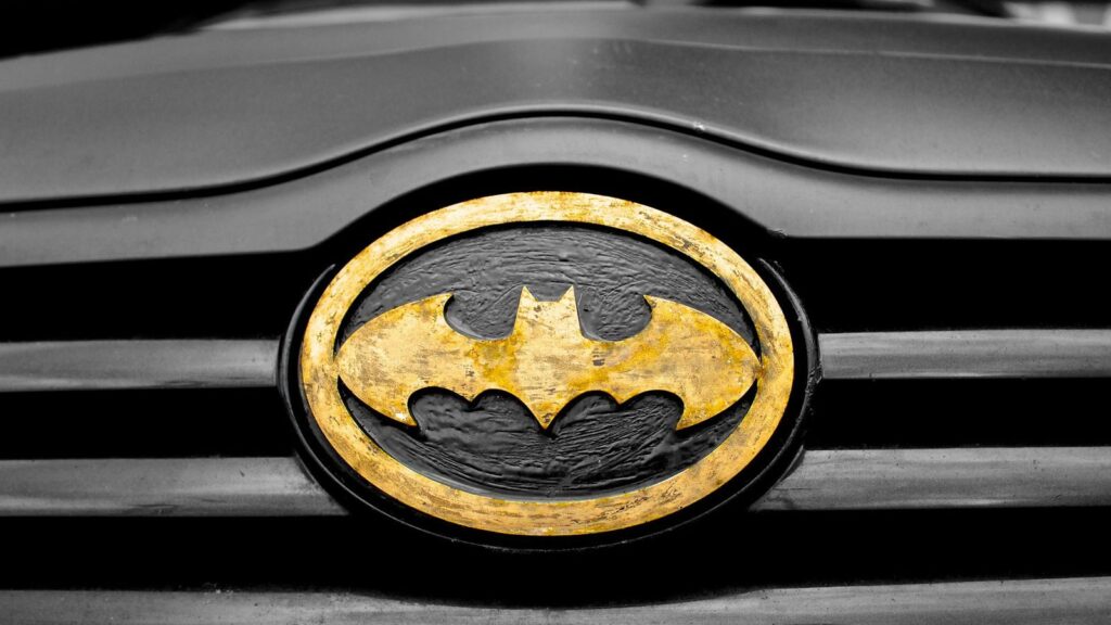 A detailed image of the iconic Batman logo on a car's grill, highlighting superhero symbolism.