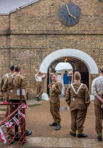 Military reenactors in historical uniforms at a heritage site in Southampton.