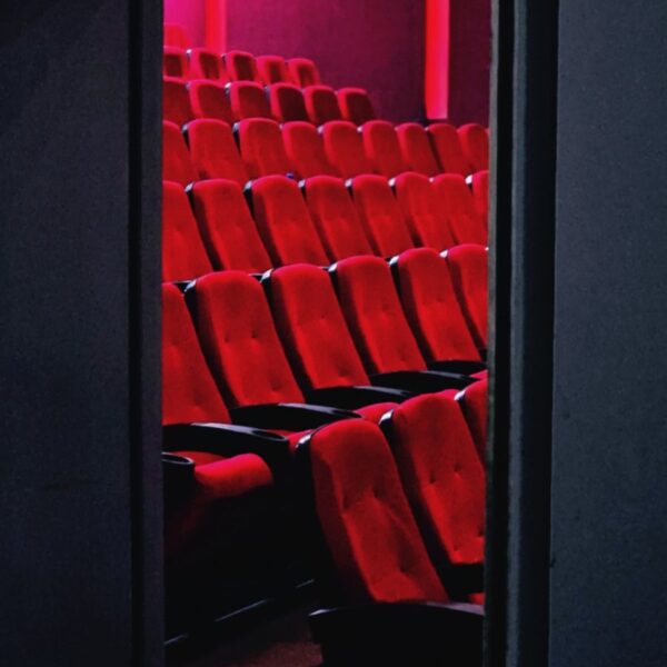 A view of empty red theater seats in a dimly lit cinema in Tehran, Iran.