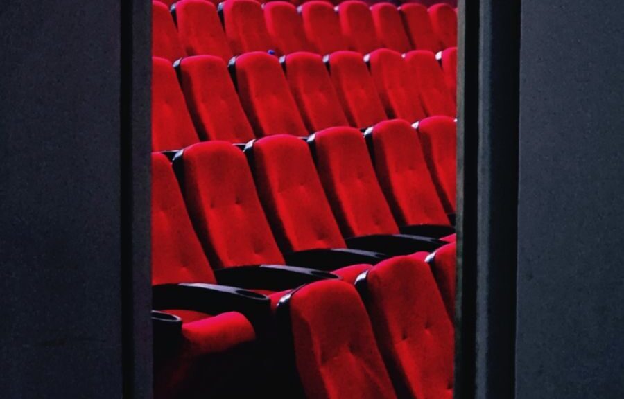A view of empty red theater seats in a dimly lit cinema in Tehran, Iran.