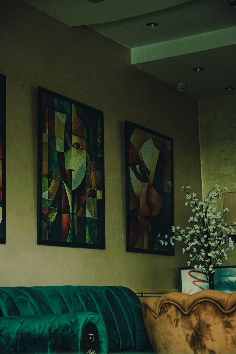 Charming Meknes cafe interior with abstract paintings, artistic vibe, vintage seating, and floral decor.