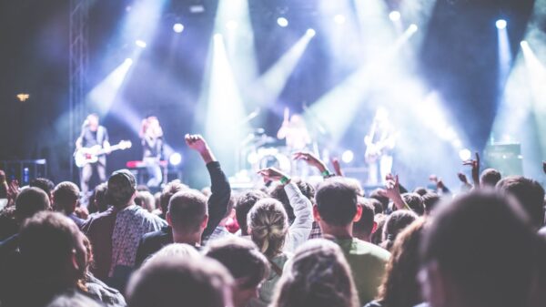 Energetic concert scene with a vibrant audience and band performing under bright lights.
