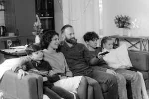 A family of five enjoying a cozy evening together on the couch, relaxing indoors.