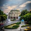 A historic building in Niš, Serbia, under a dramatic cloudy sky, showcasing elegant architecture.