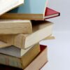 A vertical stack of various hardcover books with visible pages, ideal for literature themes.