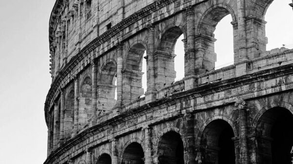 Classic black and white image of the Colosseum highlighting its architectural grandeur.