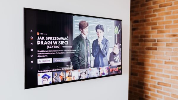 Smart TV displaying streaming content in modern living room setting with exposed brick wall.