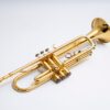 Close-up of a shiny gold trumpet isolated on a white background.