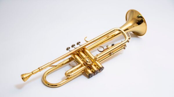 Close-up of a shiny gold trumpet isolated on a white background.