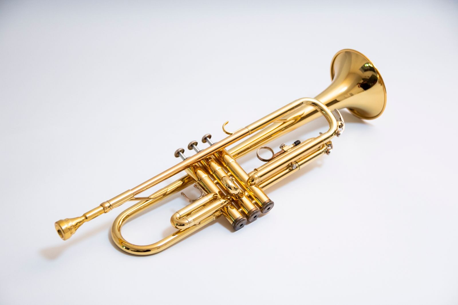 Close-up of a shiny gold trumpet isolated on a white background.