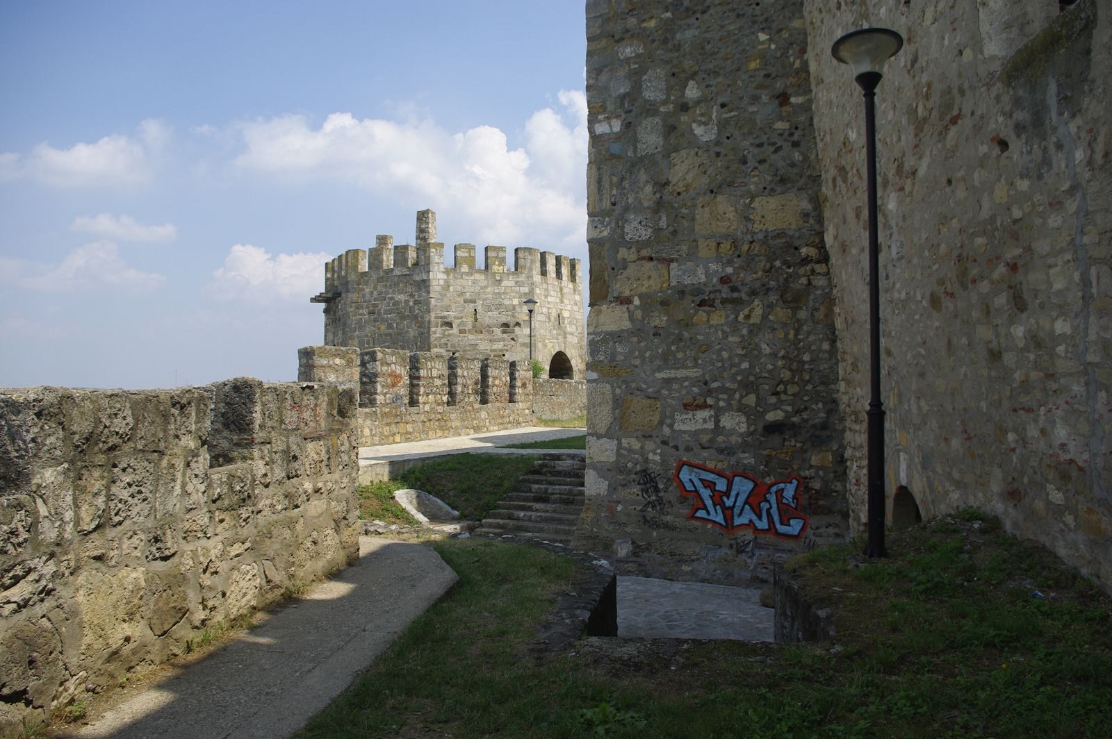 Stone fortress walls at Smederevo with sky in the background. Featuring graffiti and an ancient architectural style.