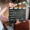 Close-up of hands holding a film slate board in an artistic indoor setting.