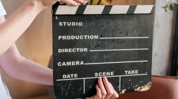 Close-up of hands holding a film slate board in an artistic indoor setting.
