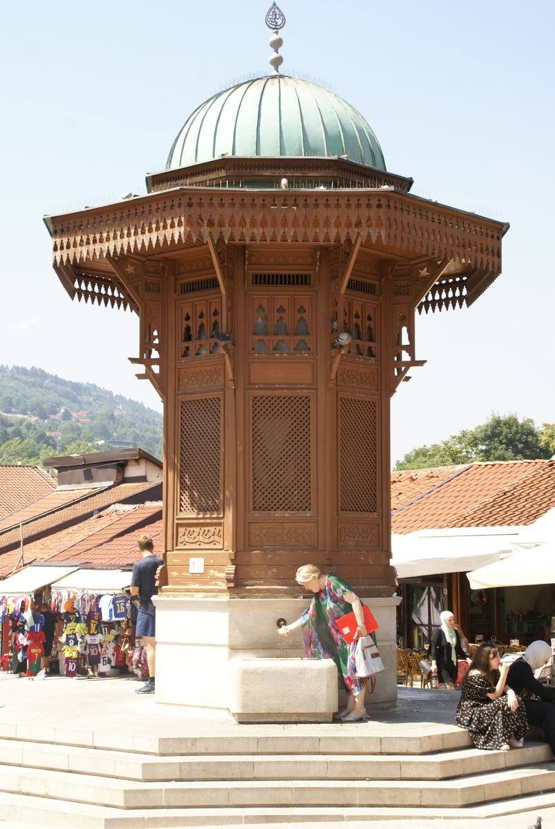 A vibrant scene at the Gazi Husrev-beg's Sebilj Fountain in Sarajevo, capturing cultural essence and tourism.