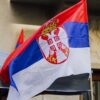 Close-up of a waving Serbian flag against urban backdrop in Belgrade city.