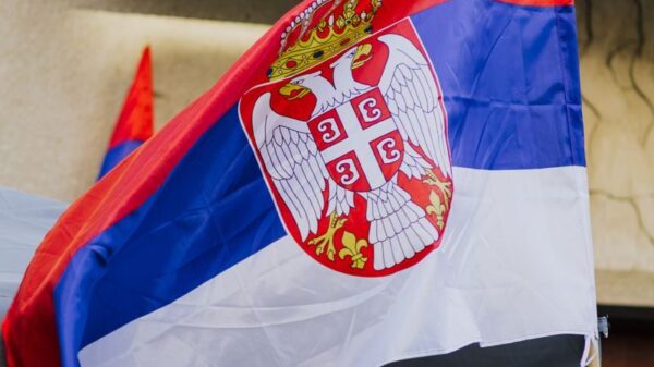 Close-up of a waving Serbian flag against urban backdrop in Belgrade city.