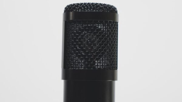 Close-up of a black microphone against a white backdrop, perfect for audio recording themes.