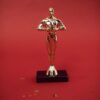 A shiny golden trophy standing against a vivid red backdrop, symbolizing achievement.