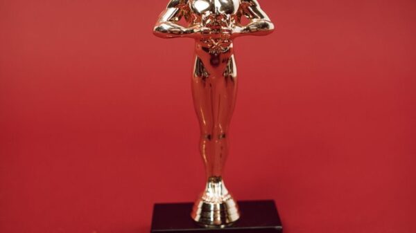 A shiny golden trophy standing against a vivid red backdrop, symbolizing achievement.