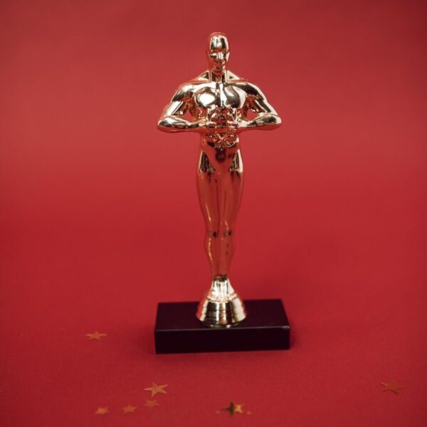 A shiny golden trophy standing against a vivid red backdrop, symbolizing achievement.