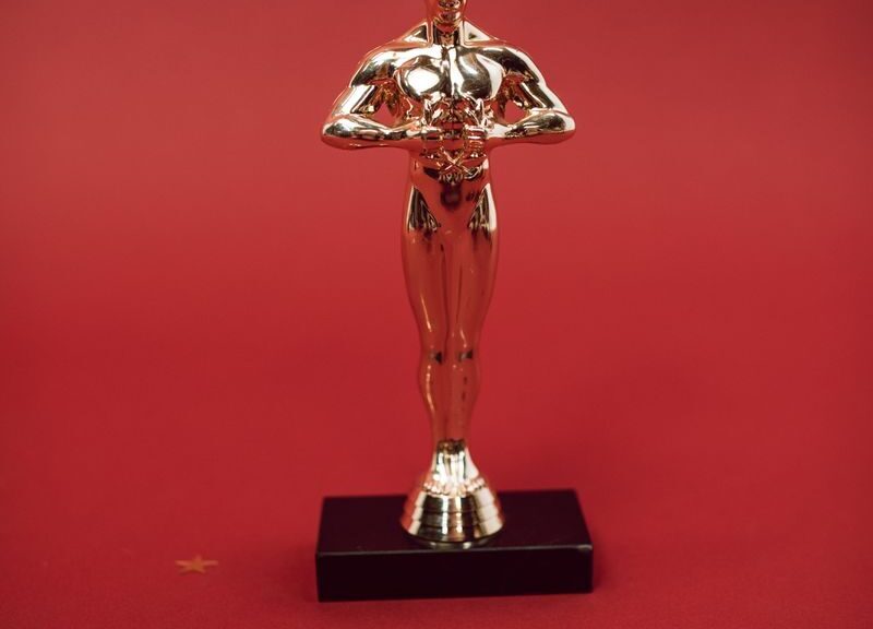 A shiny golden trophy standing against a vivid red backdrop, symbolizing achievement.