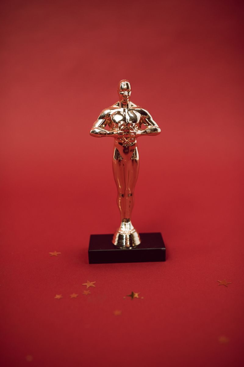 A shiny golden trophy standing against a vivid red backdrop, symbolizing achievement.