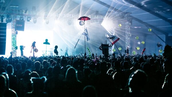 A dynamic crowd enjoying a live concert with bright stage lights and festive decorations.