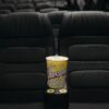 Close-up of popcorn bucket on empty cinema seats in a theater.