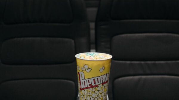 Close-up of popcorn bucket on empty cinema seats in a theater.