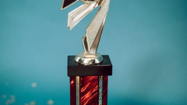 Silver and red dance trophy on blue background with stars and '20'.