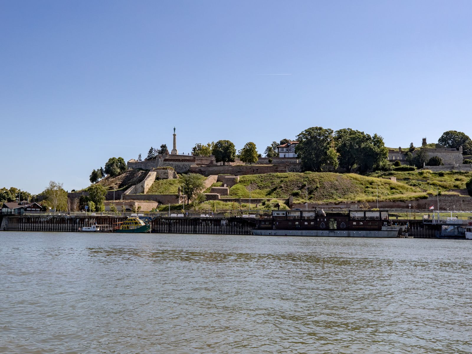 Scenic view of Belgrade Fortress and Sava River under a clear summer sky.