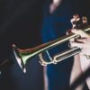 Close-up shot of a musician playing the trumpet during a live performance, highlighting musical passion.