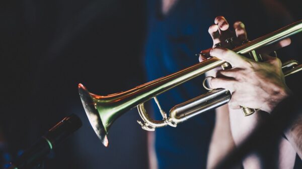 Close-up shot of a musician playing the trumpet during a live performance, highlighting musical passion.