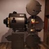 Old-fashioned Superarc film projector displayed indoors, evoking cinematic history.