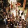 Vibrant Indian wedding procession with a groom on a decorated horse surrounded by colorful guests.